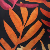 Close-up of fabric with orange and pink leaf pattern on black background